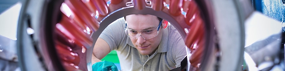 Man scooping plastic pellets into a mixing machine
